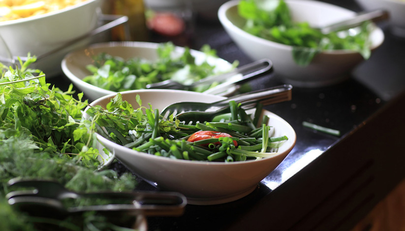 Plates with greens on a plate at the buffet